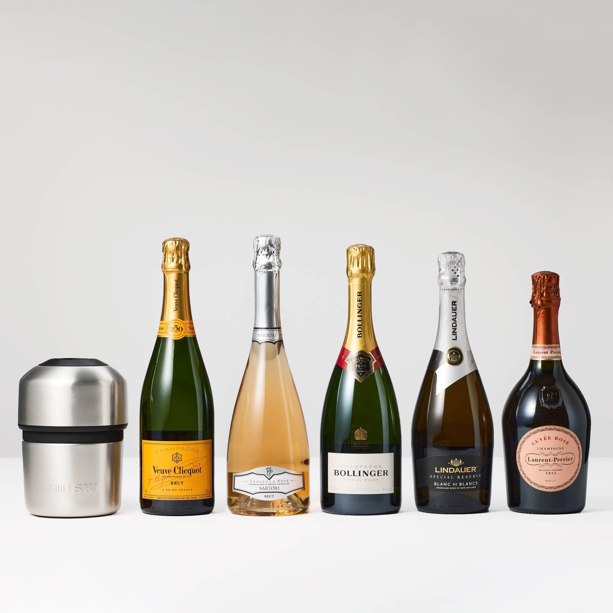 Huski Champagne Cooler in white, insulated stainless steel with a sleek design, holding a champagne bottle and ice.