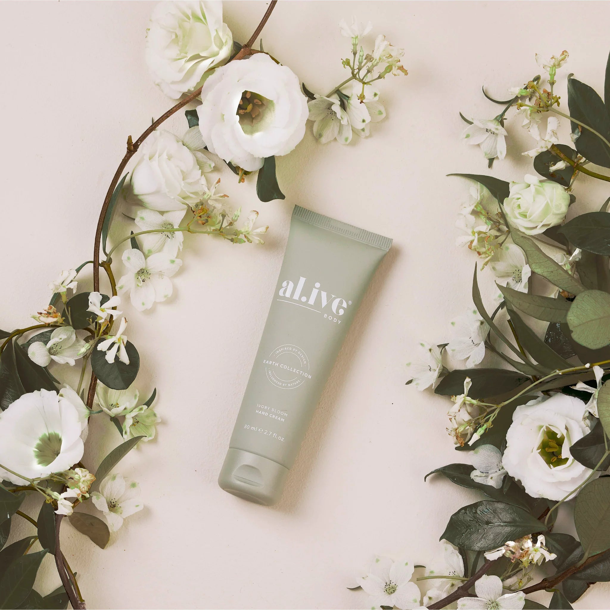 Al.ive Body Ivory Bloom hand cream in a sleek tube, showcasing the elegant packaging and creamy texture.
