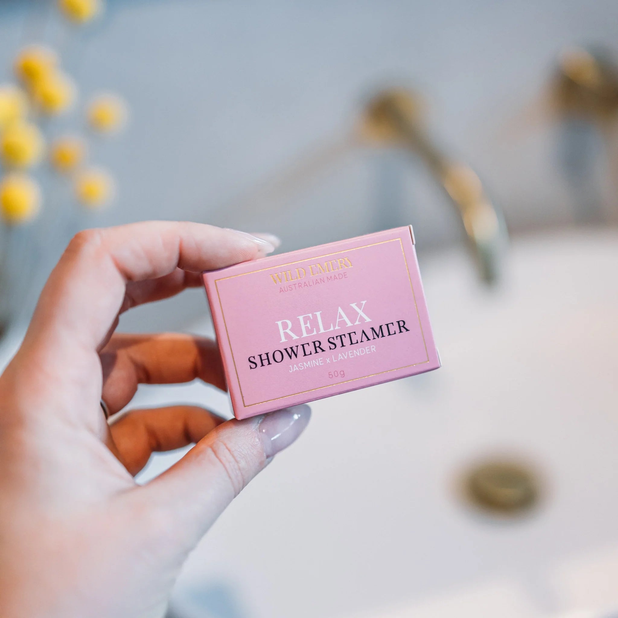 Wild Emery Relax shower steamer emitting steam with floral and herbal scents, designed for a calming shower experience.