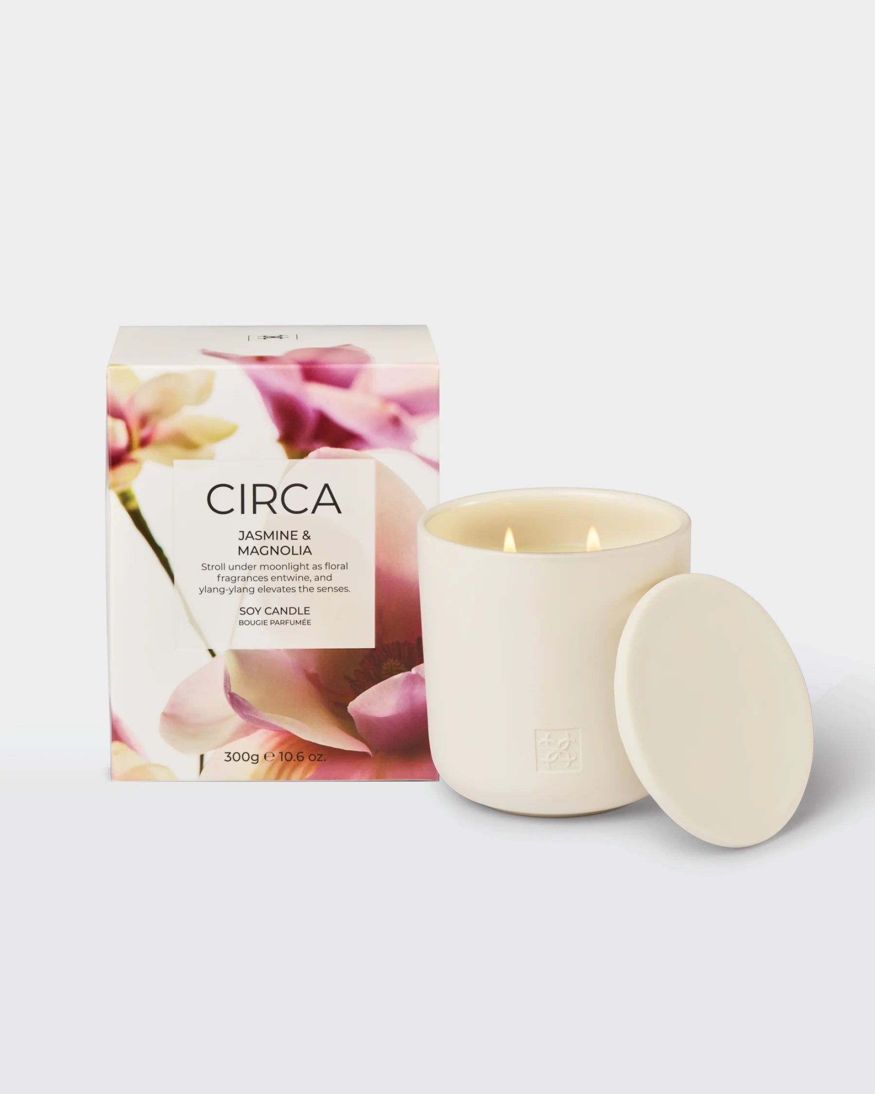 Scented jasmine and magnolia soy candle in a 300g glass jar by Circa, with a lit wick and floral design on the label.