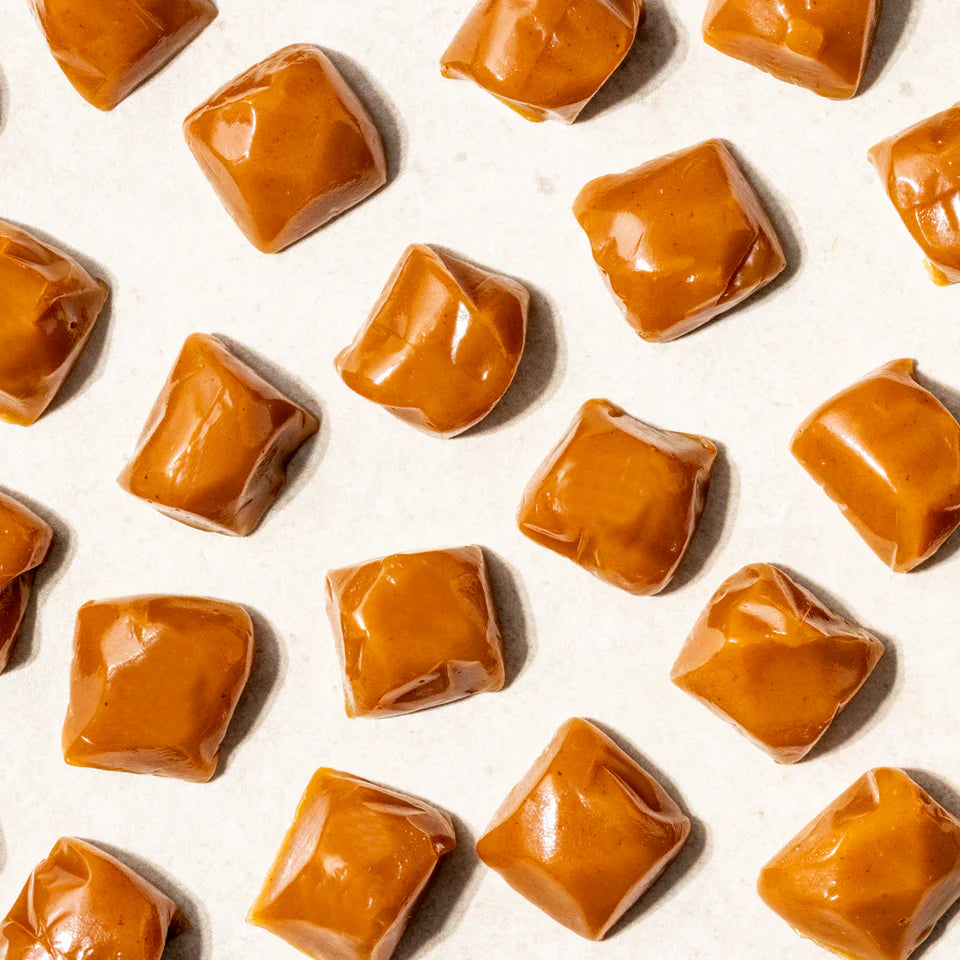 Classic Caramel from New Farm in a 100g package, showcasing rich caramel pieces with a smooth, glossy texture.