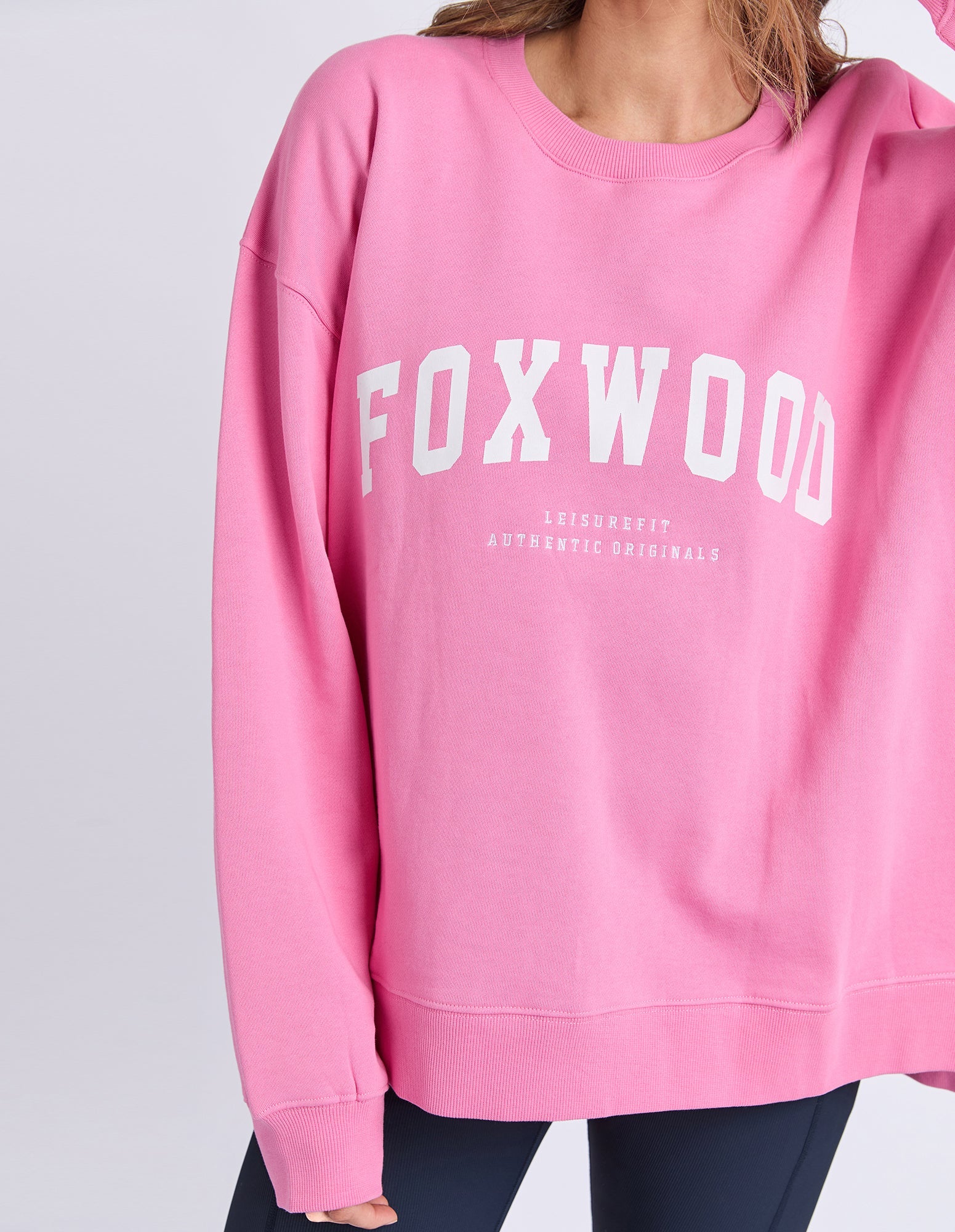 Foxwood Interval Crew Bubblegum Pink sweatshirt displayed on a hanger with a close-up of the fabric and color.