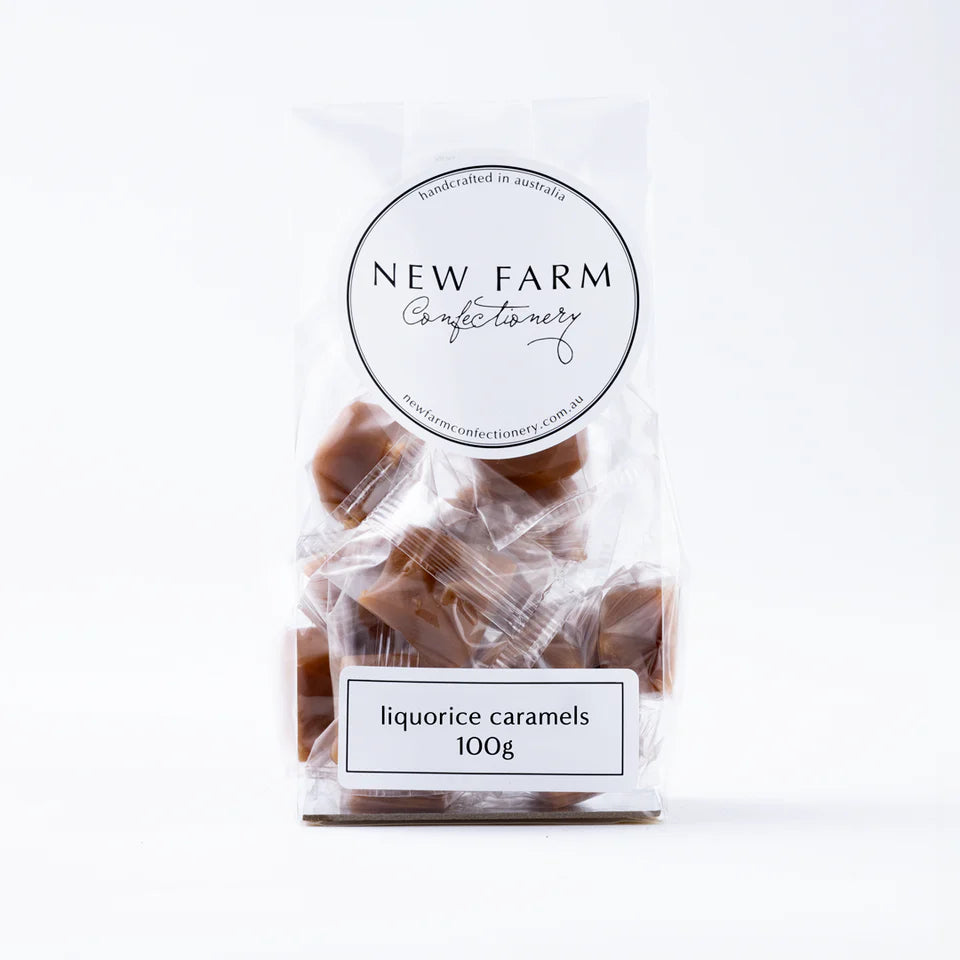 Close-up of New Farm Liquorice Caramel 100g, showing golden caramel candies with black liquorice pieces in a clear wrapper.