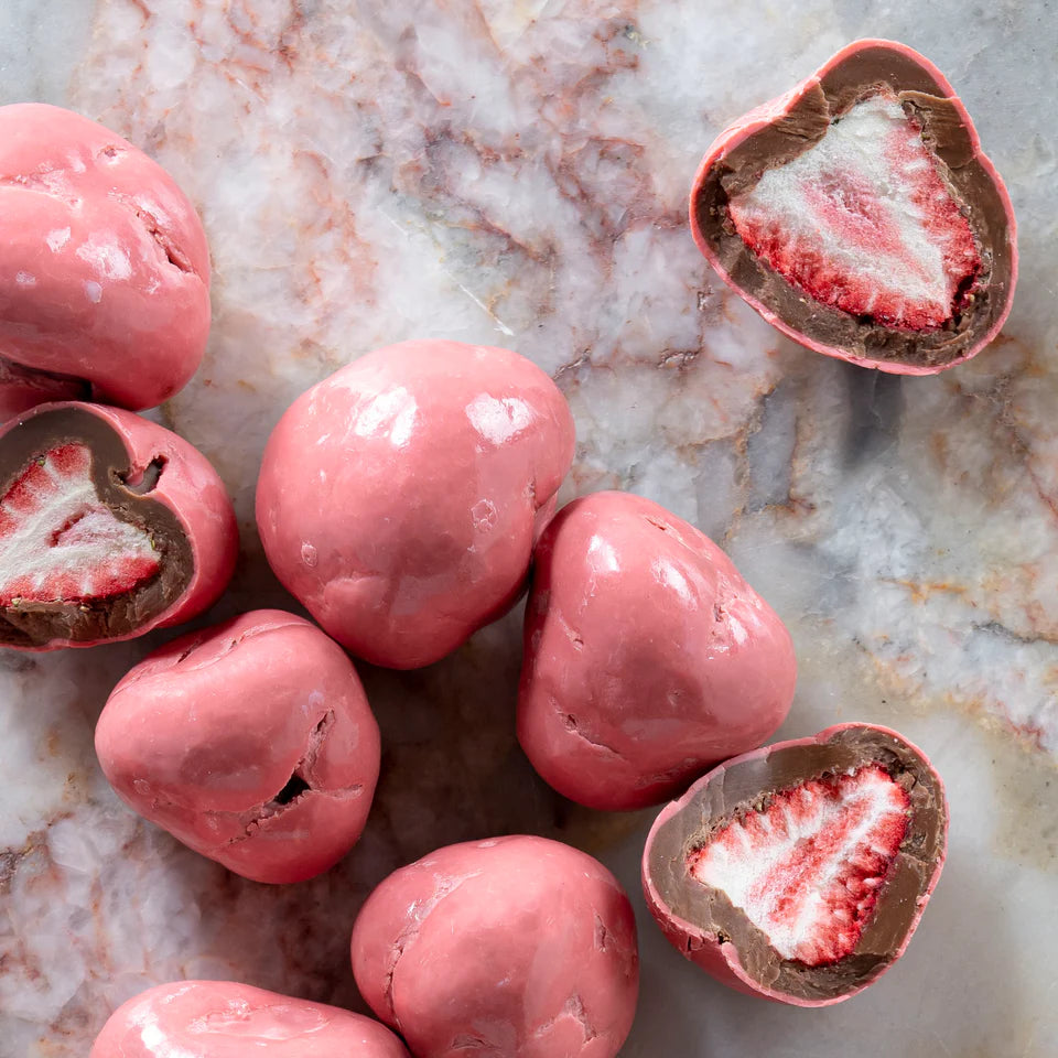 Milk chocolate-coated whole strawberries in a 150g package by New Farm, with glossy chocolate coating and fresh strawberry interior.