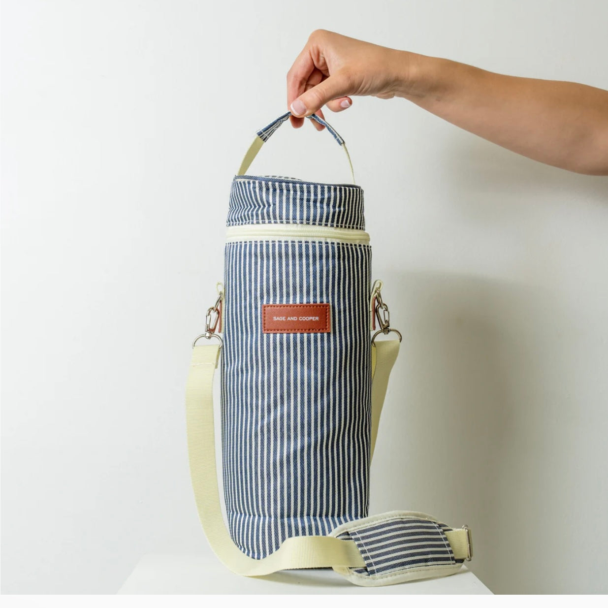 Sage & Cooper denim stripe wine cooler bag with adjustable strap and insulated interior for keeping wine chilled.