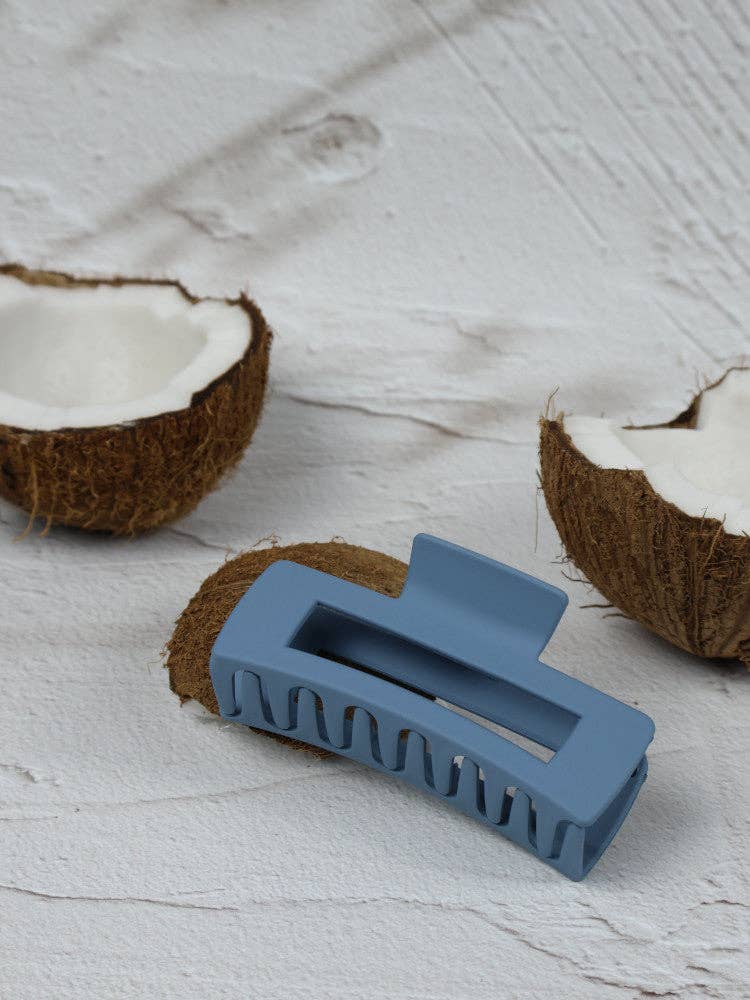 Medium blue elongated rectangle claw clip by Nakoa The Label, shown in a close-up image.