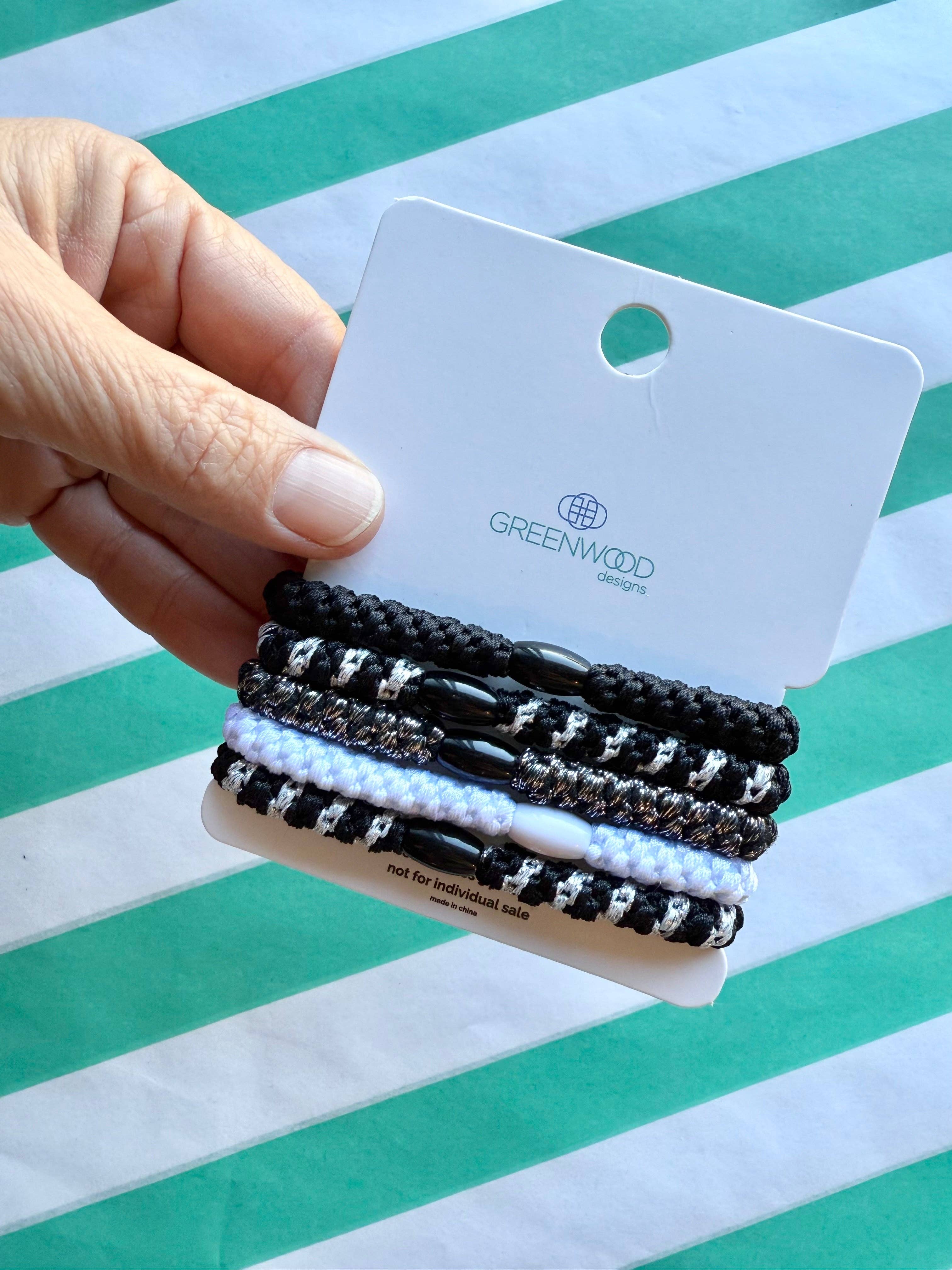 Greenwood Designs Humbug hair elastics pack with multiple black elastic bands on a white background.