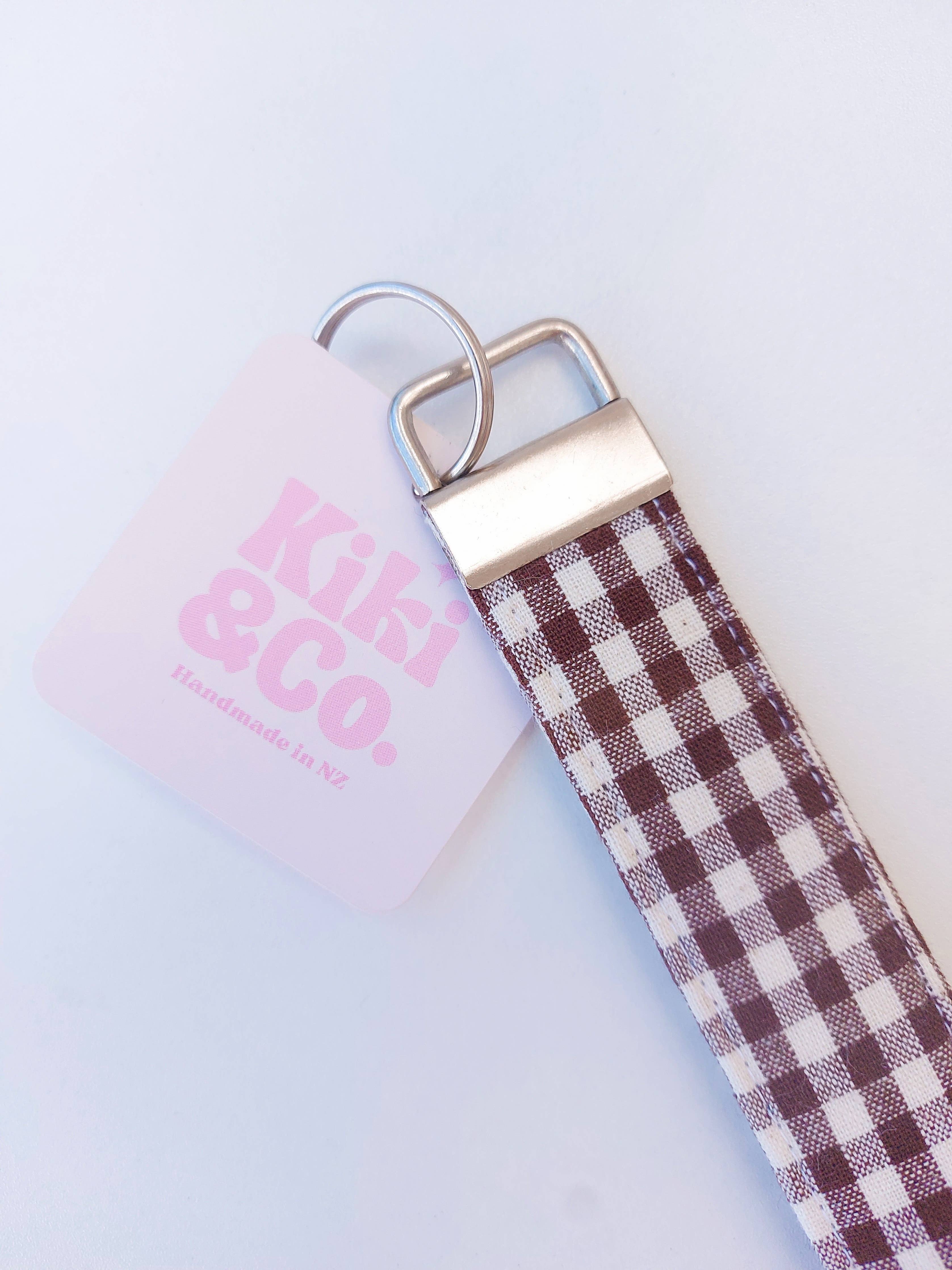 Kiki & Co. chocolate gingham keychain with fabric loop and metal clasp, featuring a stylish checkered pattern.
