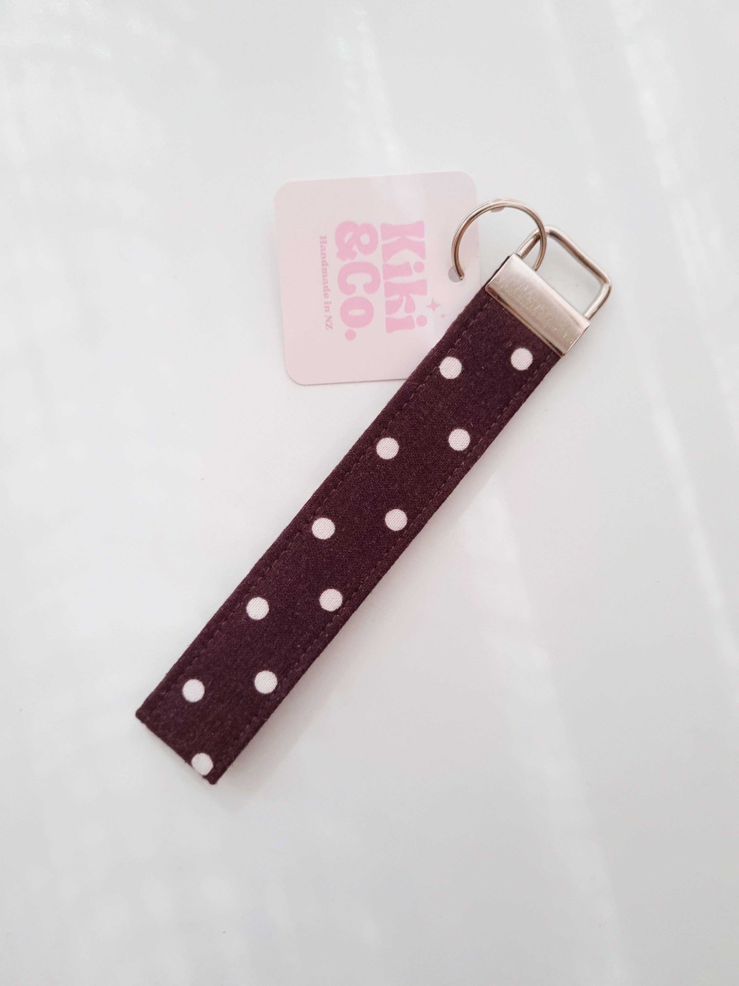 Kiki & Co. chocolate polka dot keychain with round shape and dotted pattern hanging from a metal keyring.