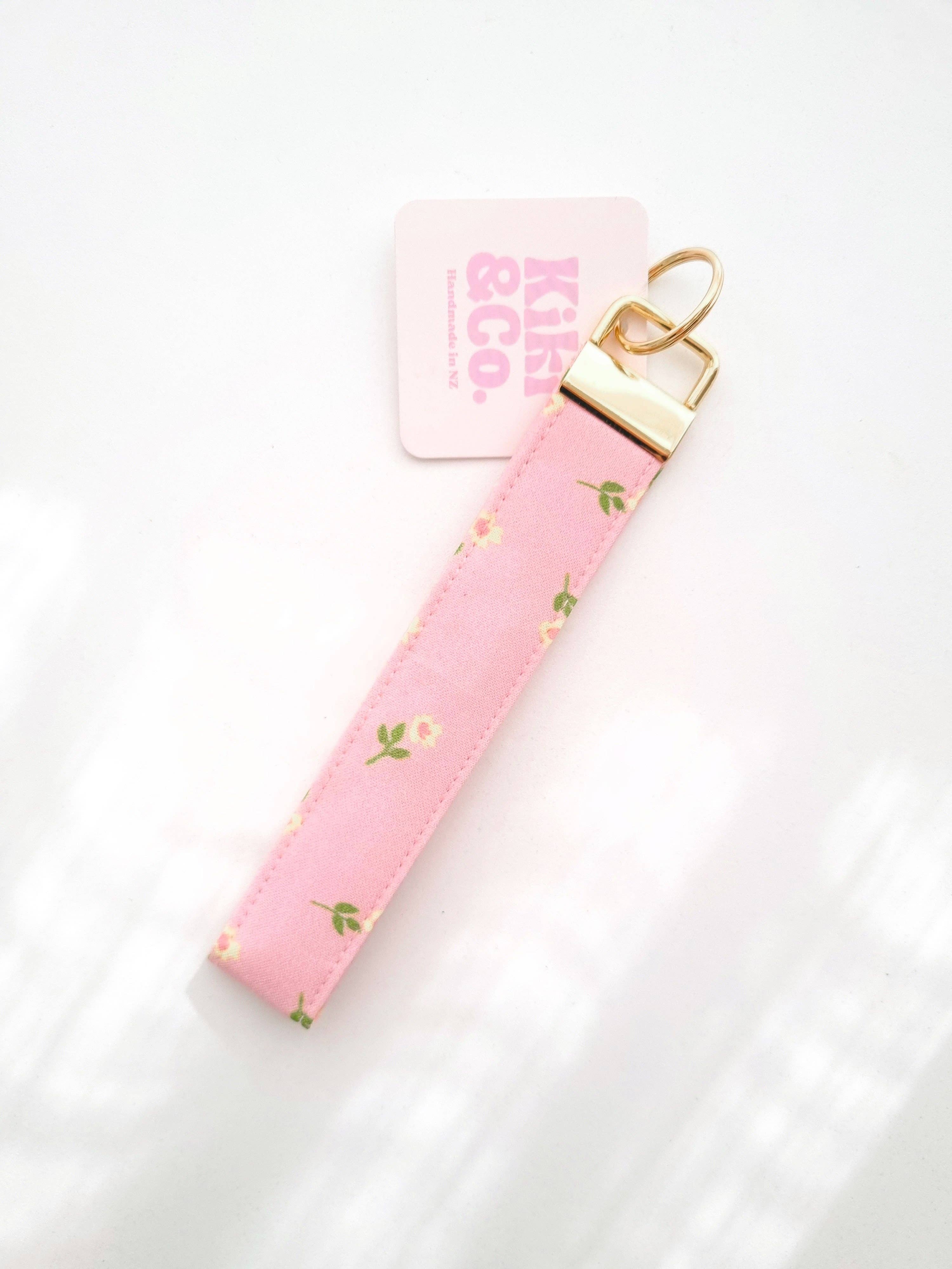 Pink petal-shaped keychain by Kiki & Co. with delicate floral design and silver keyring attachment.