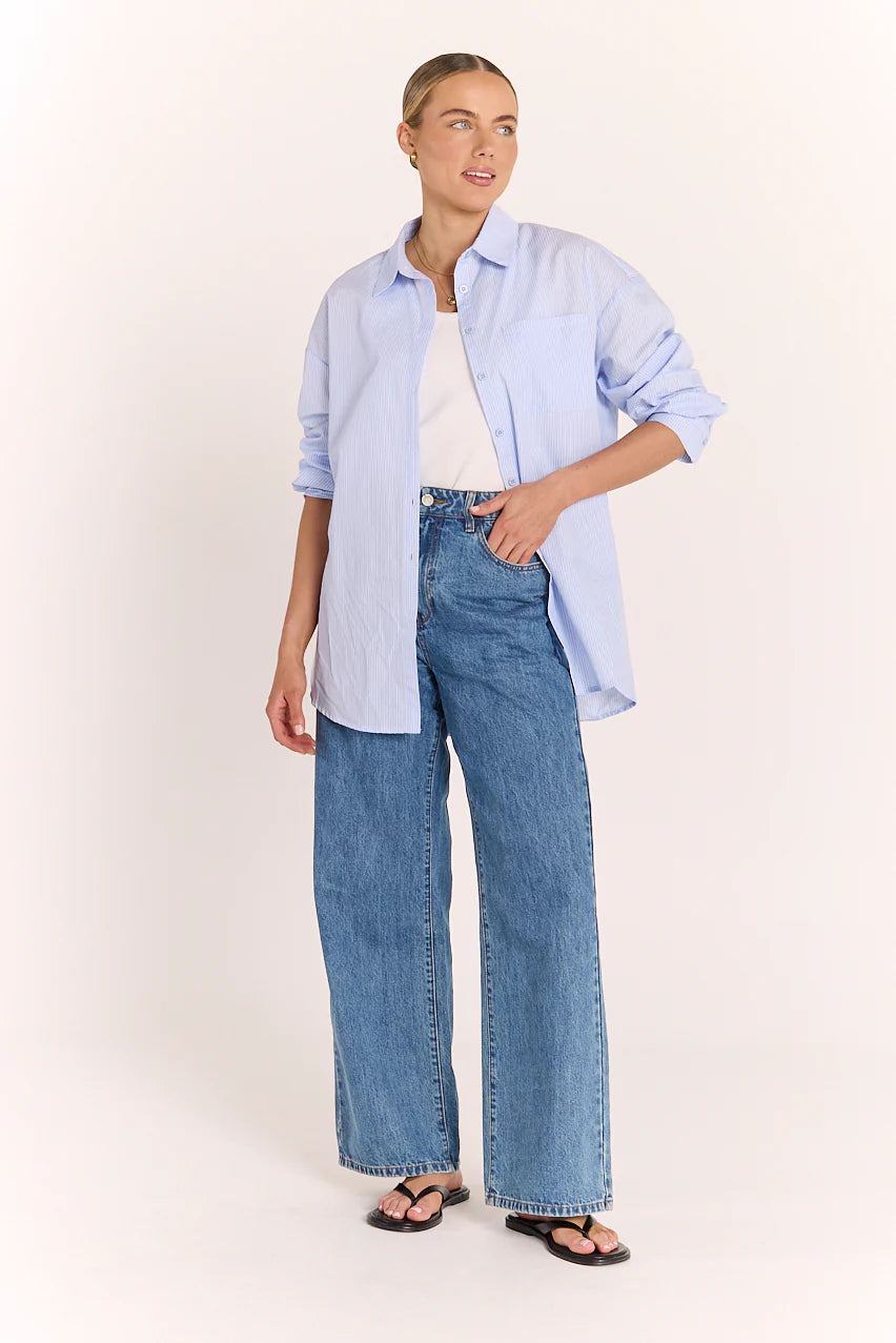 Blue and white striped Emily Shirt by Feather + Noise, displayed on a hanger with a close-up view of the fabric and collar.