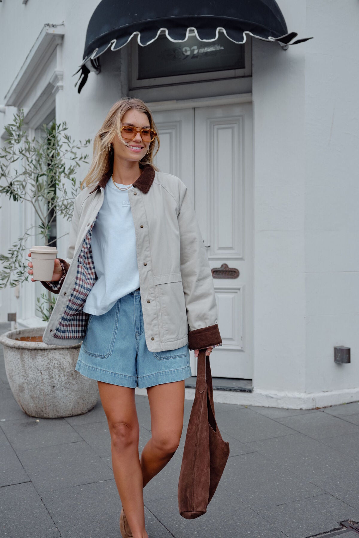 Ceres Life Blair Barn Jacket hanging on a wooden coat rack, showcasing its rustic design and durable fabric.