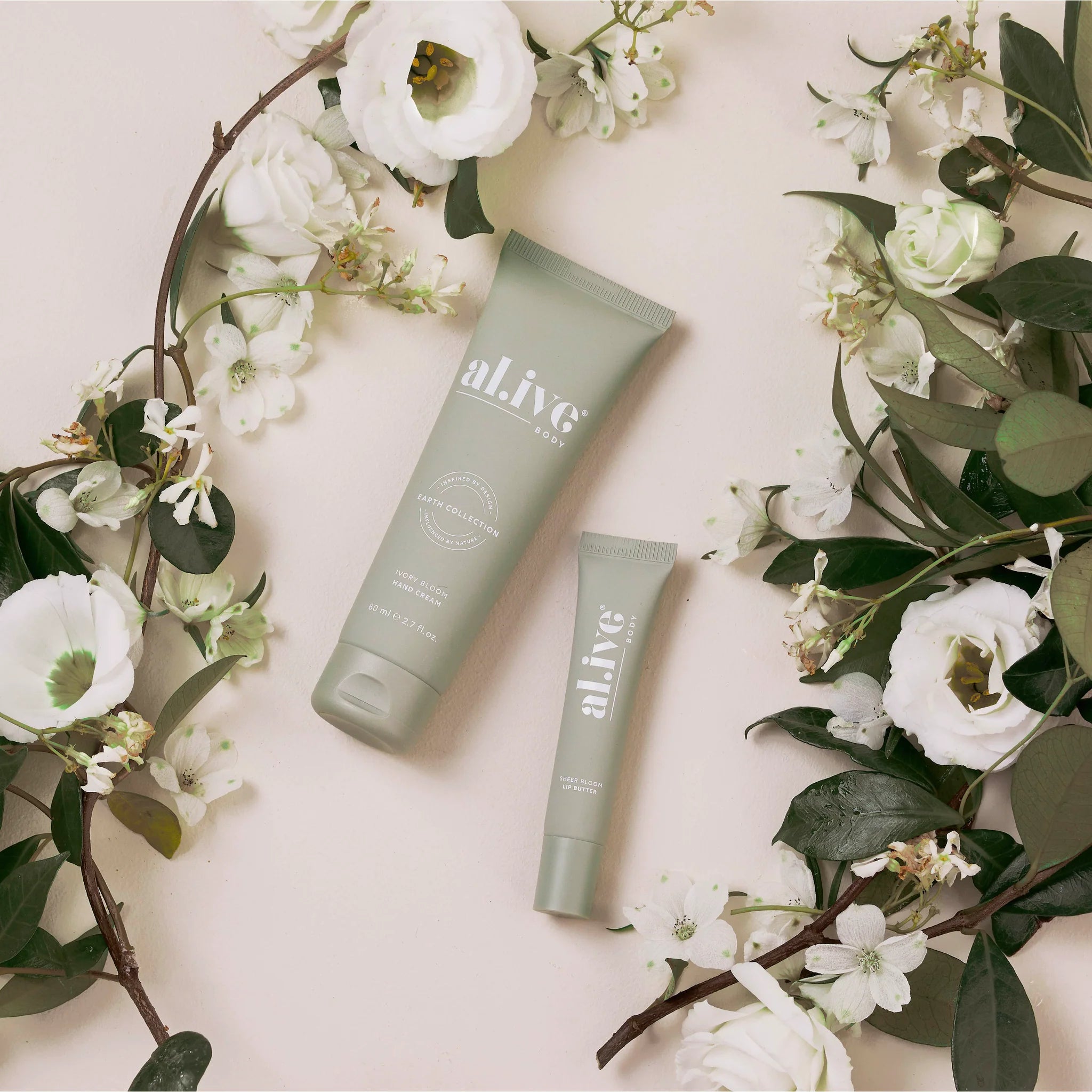 Ivory Bloom Al.ive Body hand and lip set with ivory-colored packaging and floral accents, featuring hand cream and lip balm.