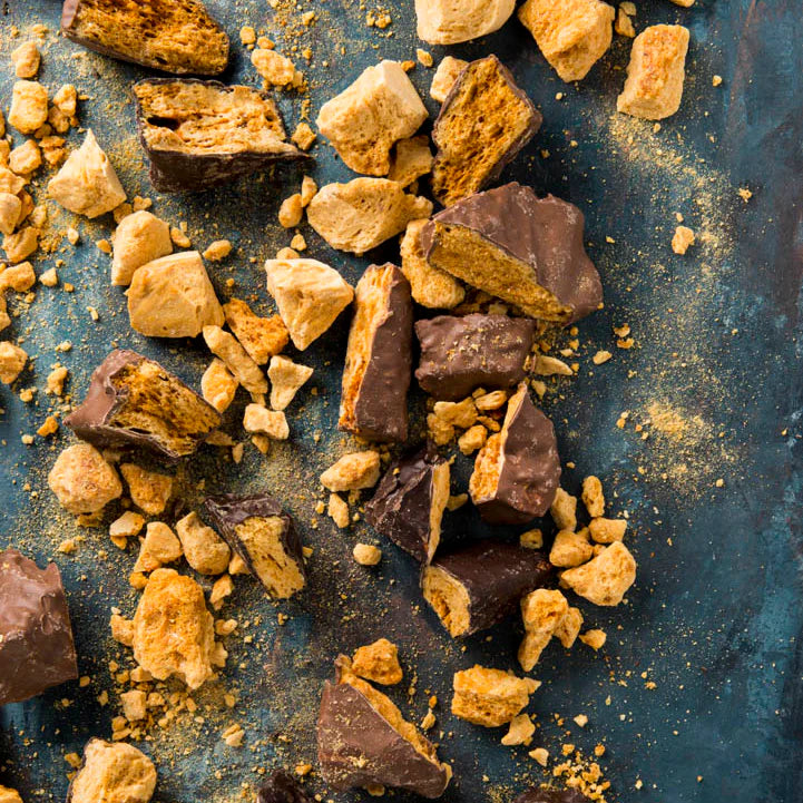 Milk chocolate honeycomb candy from New Farm, 150g, shown in the image with crispy honeycomb coated in smooth milk chocolate.