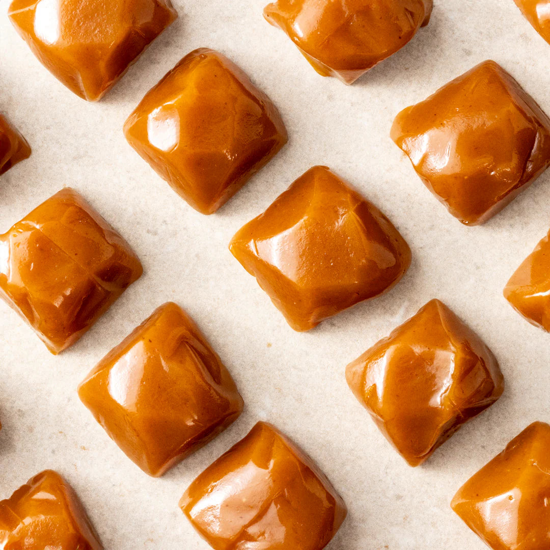Golden Classic Caramel from New Farm in a 100g package, showing smooth, rich caramel squares on a white background.
