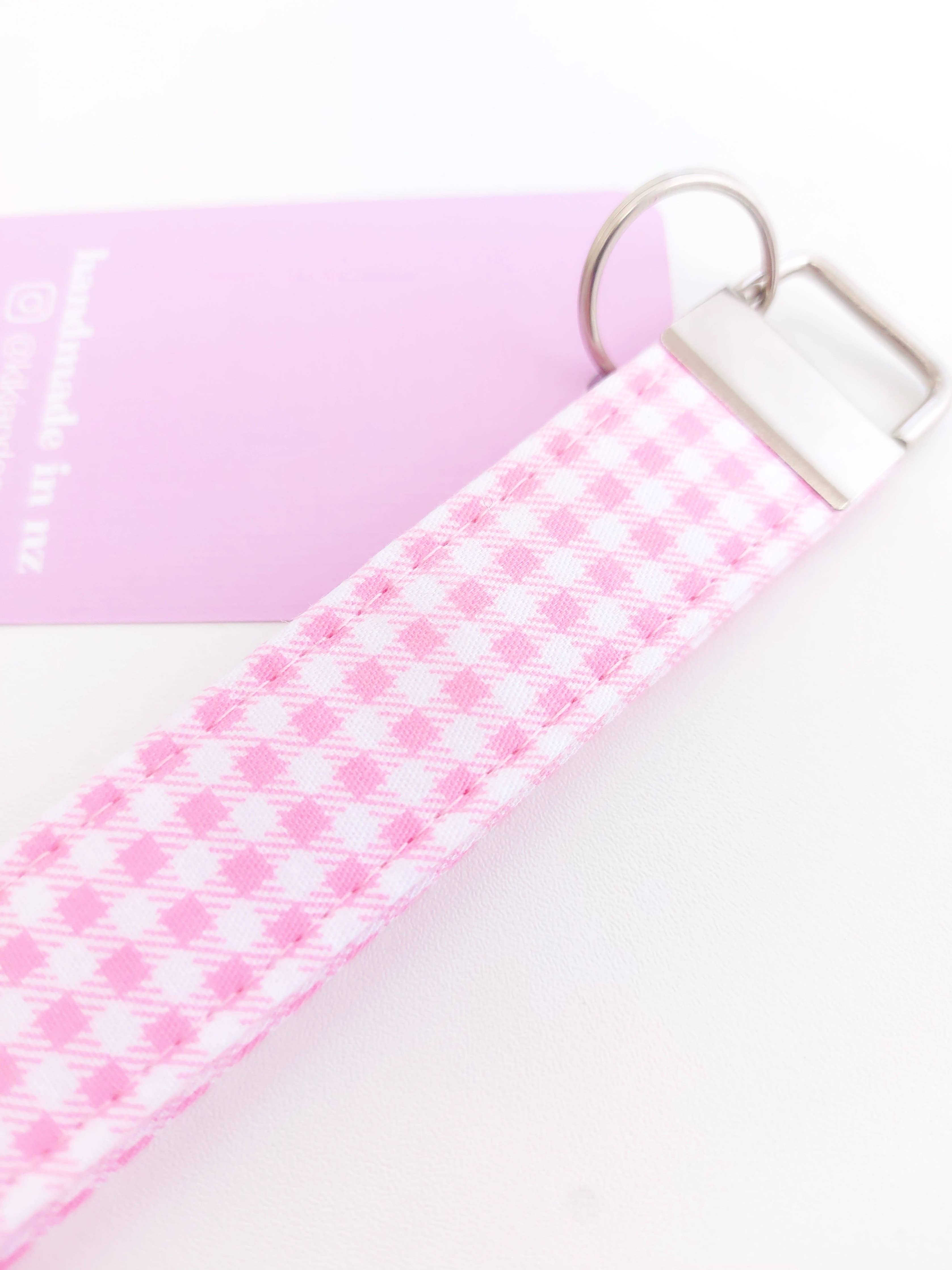 Pink gingham keychain from Kiki & Co., featuring a fabric-covered design with a small metal clasp for attaching keys.