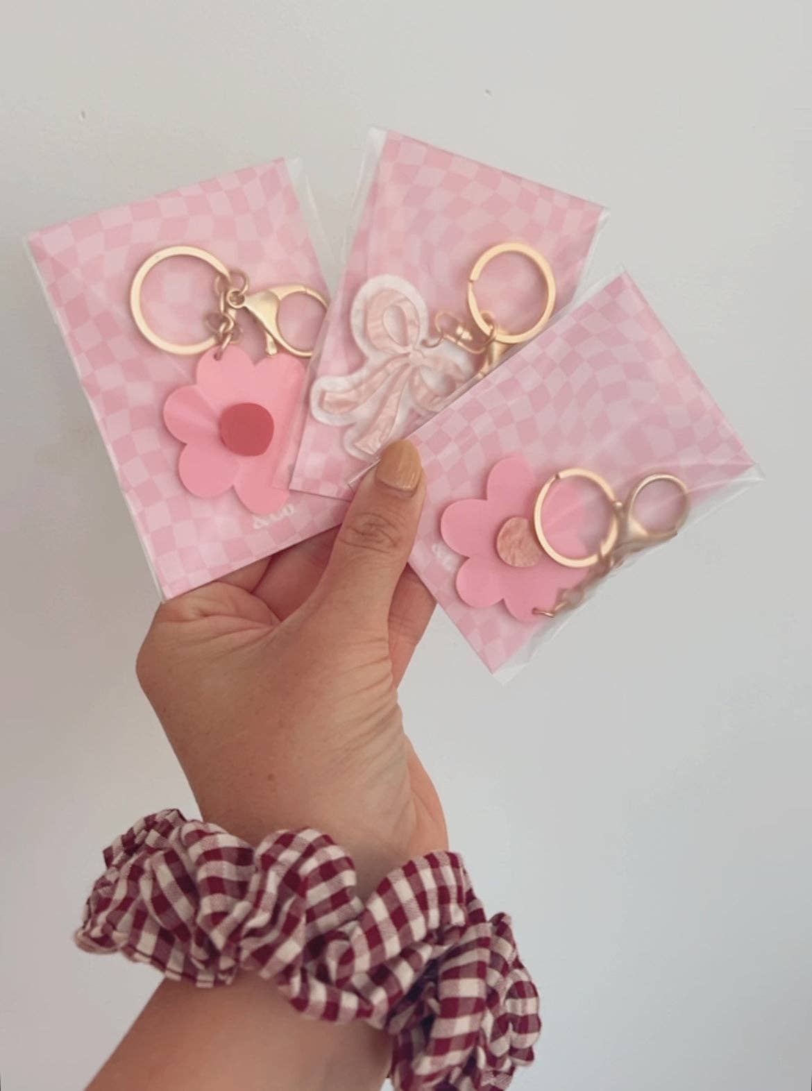 Kiki & Co. bow keyring with pastel pink and white fabric bow attached to a silver keyring.