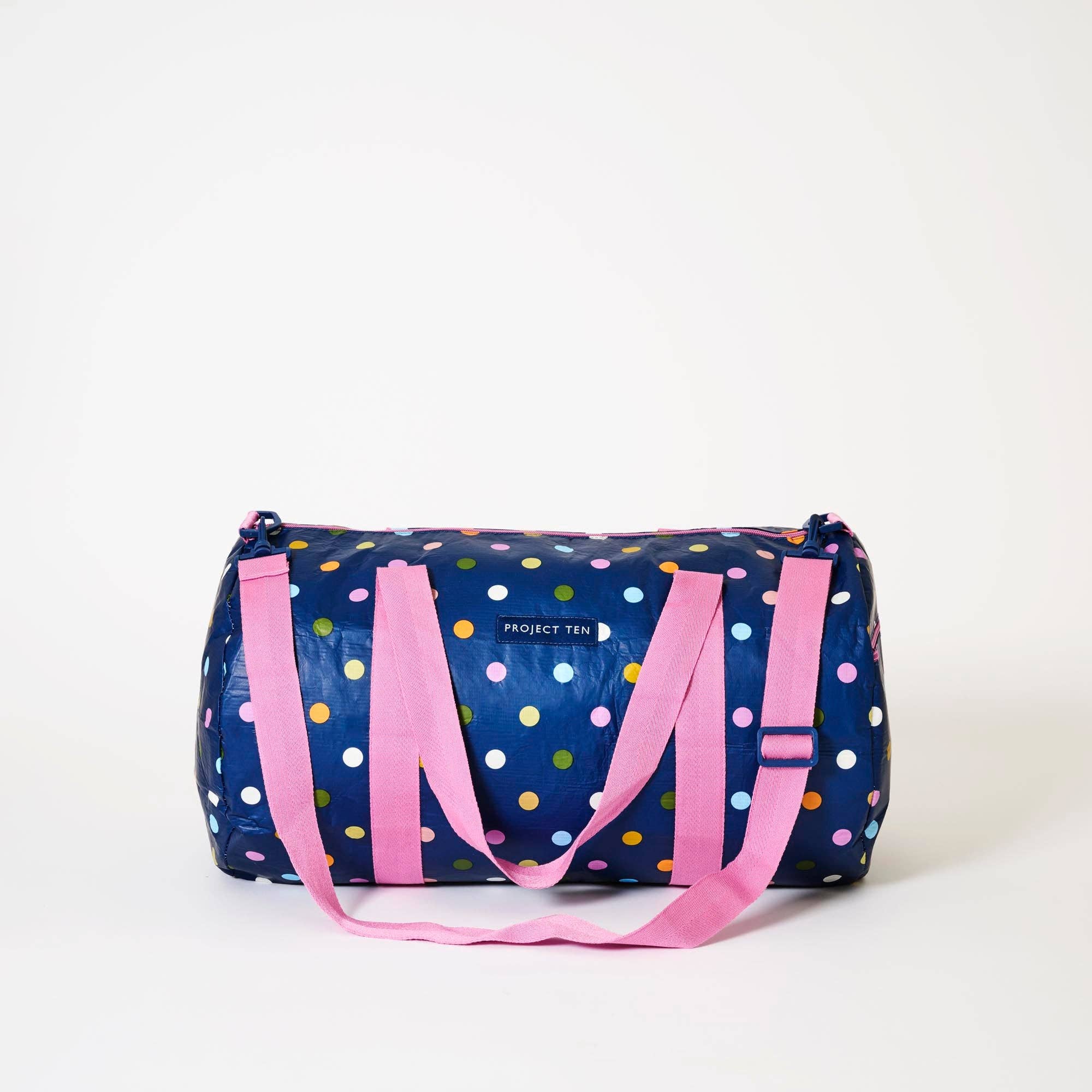 Confetti barrel bag by Project Ten Pty Ltd featuring a vibrant, colorful confetti pattern and sturdy leather straps.